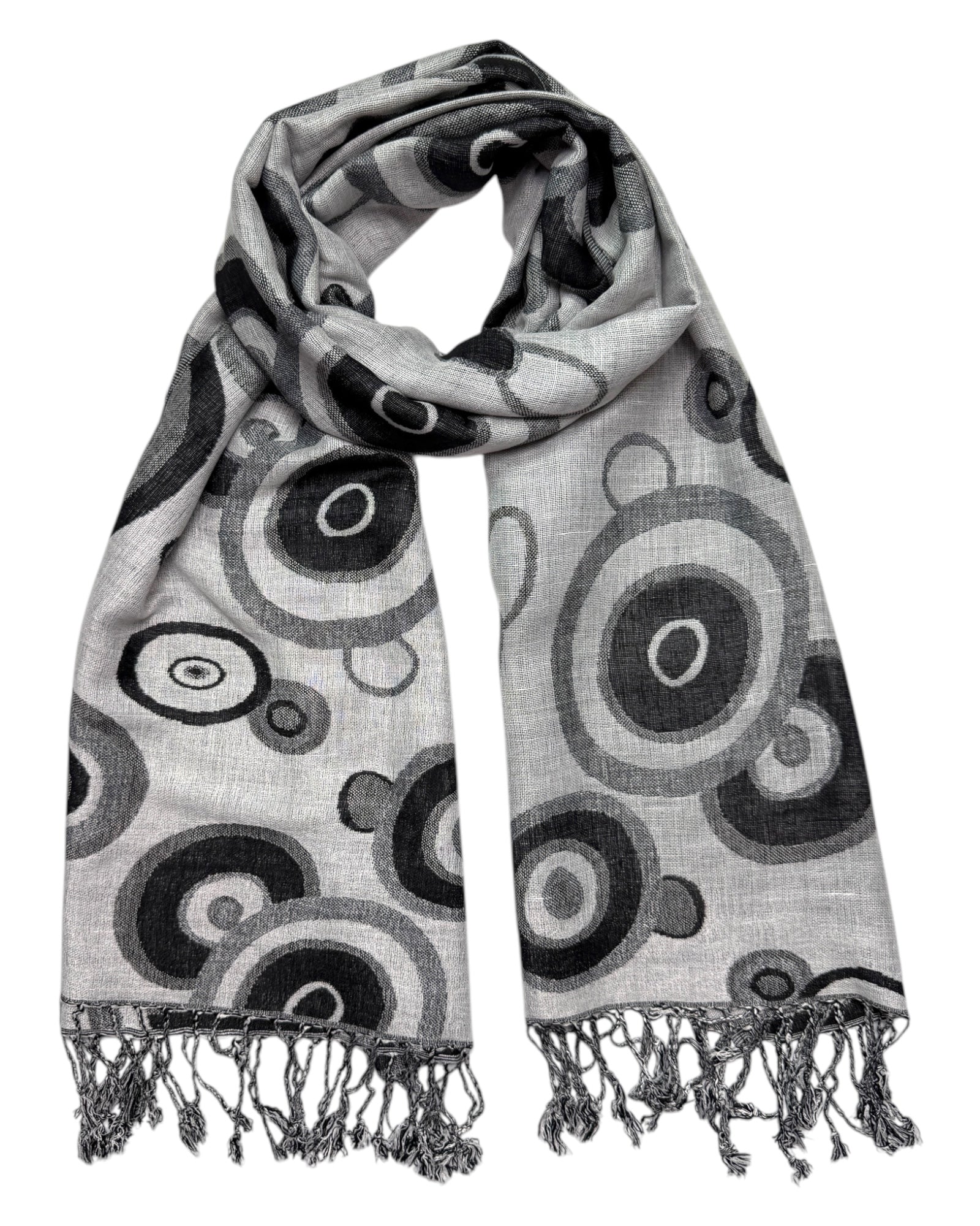 A pashmina scarf with a black and white swirl pattern, displaying a reversible design, with fringes on the ends.