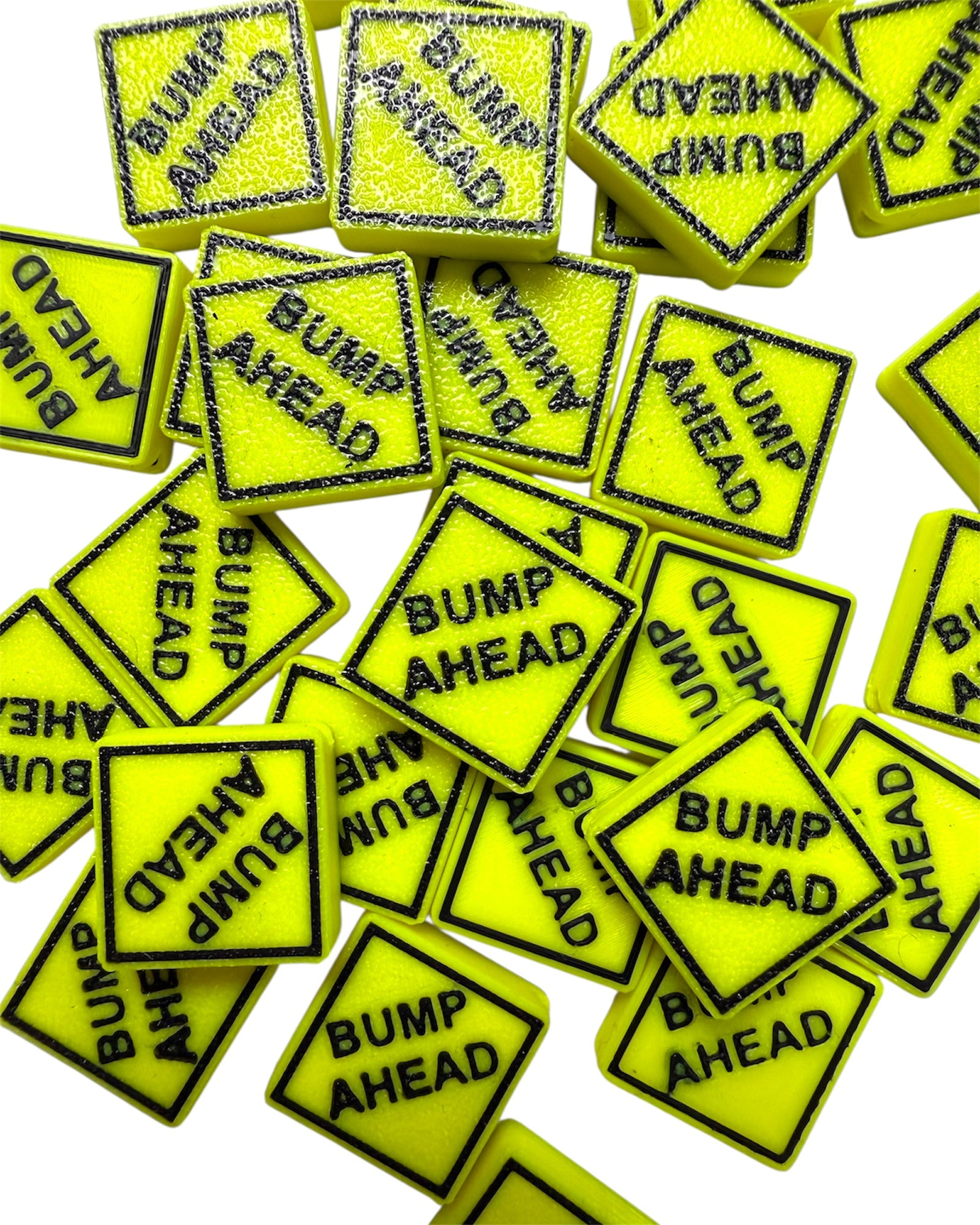 Multiple yellow 'Bump Ahead' sign kandi beads with black text on a white background