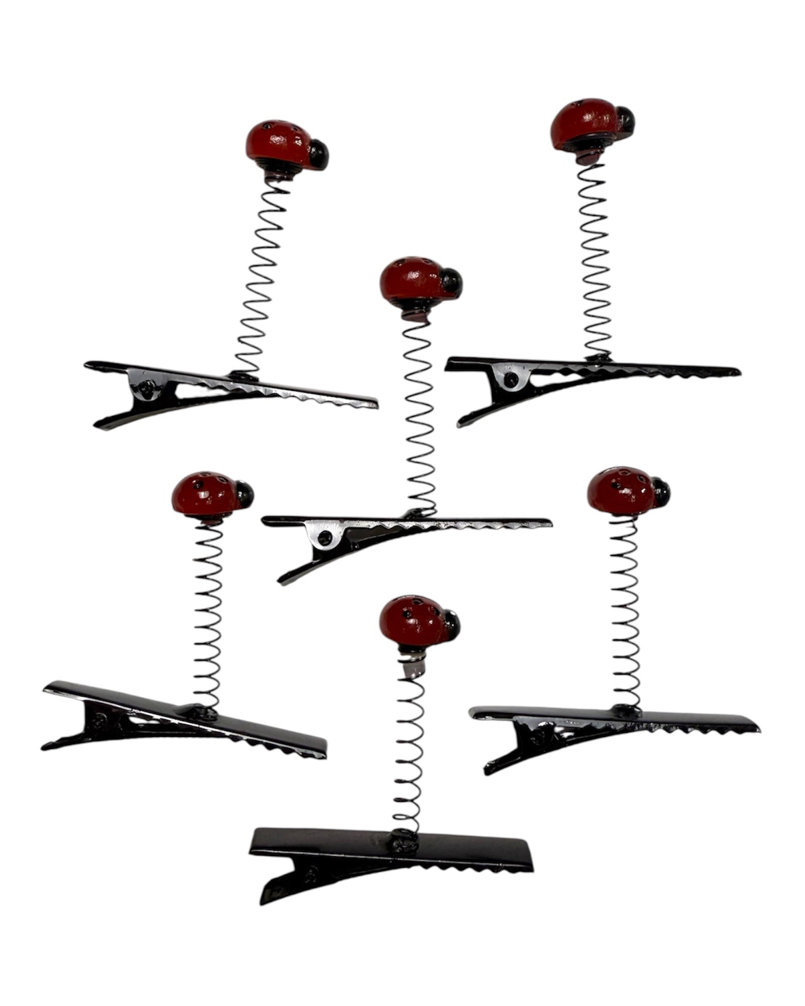 Set of hair clips with red ladybug designs on a white background