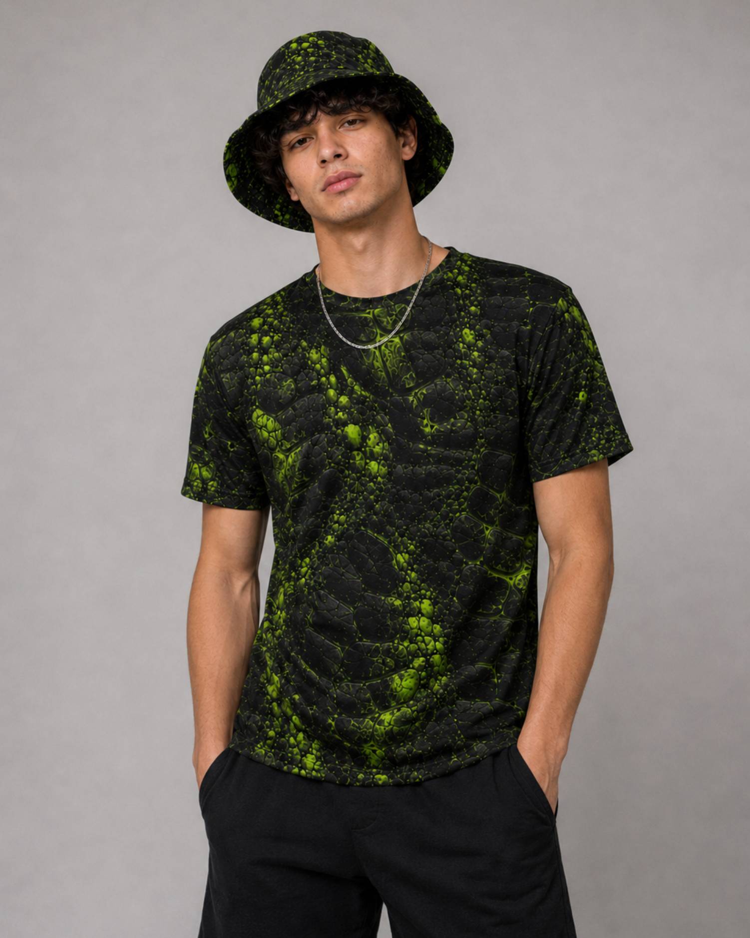 Model wearing a black and neon green cracked-texture bucket hat and matching T-shirt part of the ravage collection.