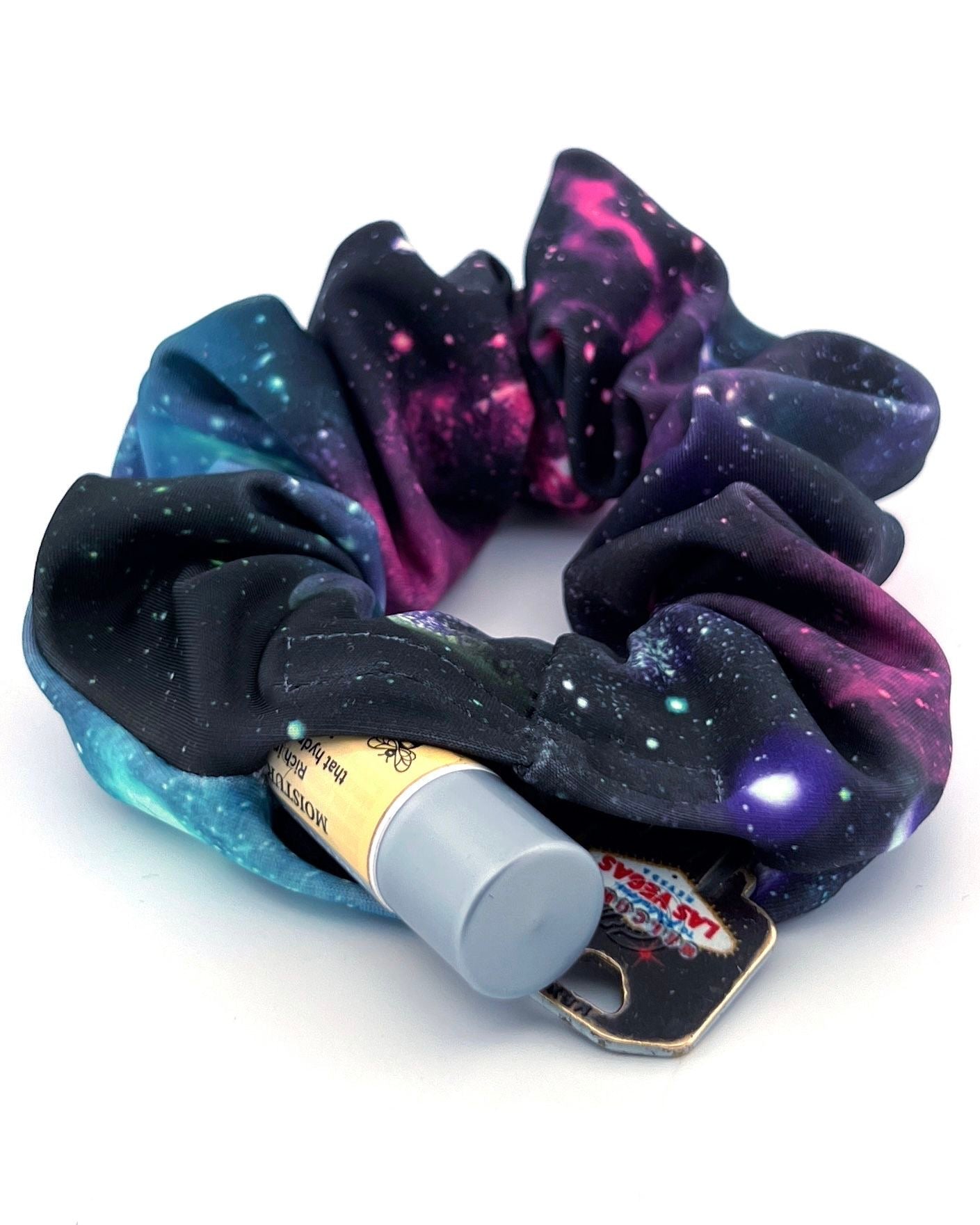 The Space Dust Stashie laid flat, displaying its vibrant galaxy-inspired design with a discreet 2-inch Velcro® pocket for small essentials.