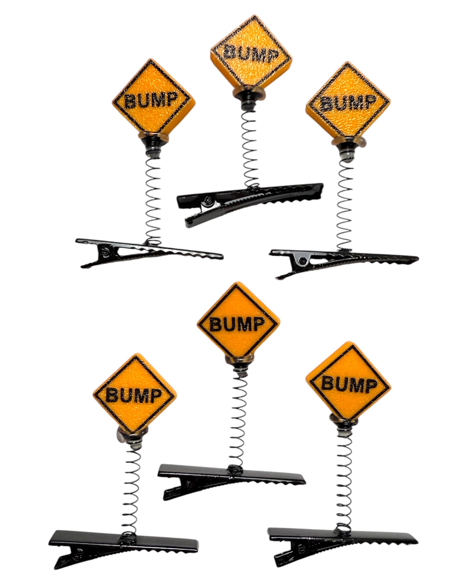 Set of hair clips with yellow 'BUMP' sign design on a white background