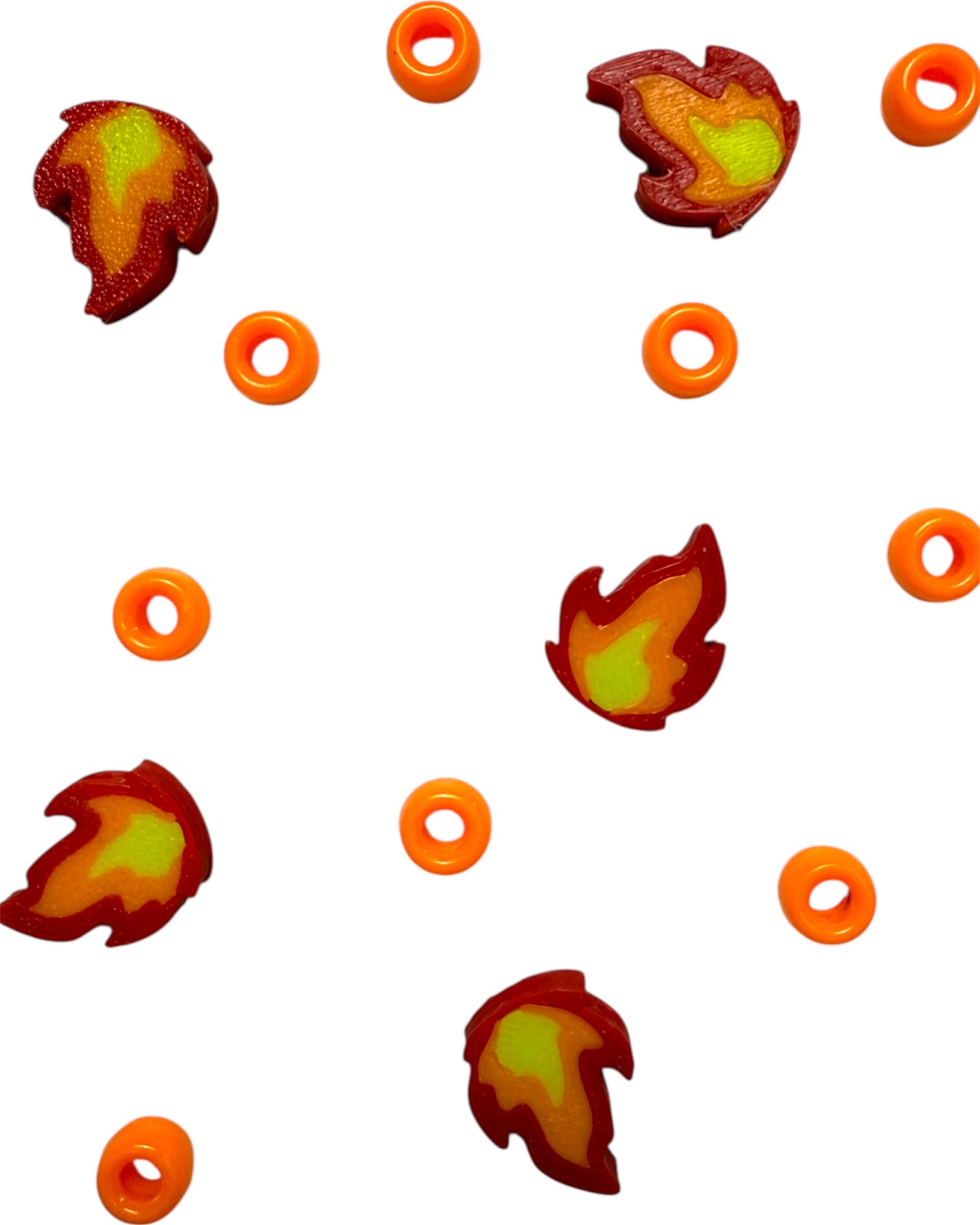 Pile of Fire Kandi Rave Beads with drilled bead holes for kandi bracelet stringing and festival crafts.