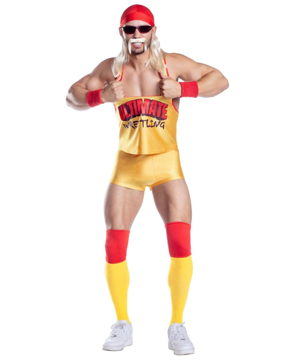 A man modeling a yellow and red wrestling costume with a matching red cap, sunglasses, wristbands, knee sleeves, and yellow-and-red knee socks against a plain white background.