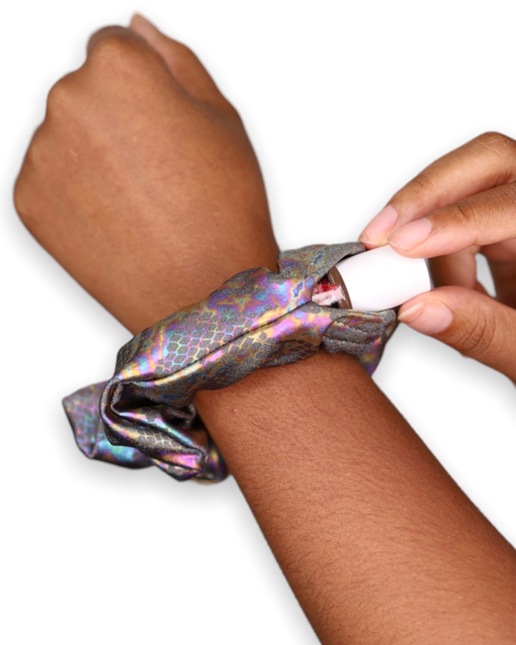 The Prismatic Venom Stashie being worn on the wrist, showing its iridescent snakeskin fabric and hidden Velcro® pocket holding lip balm.