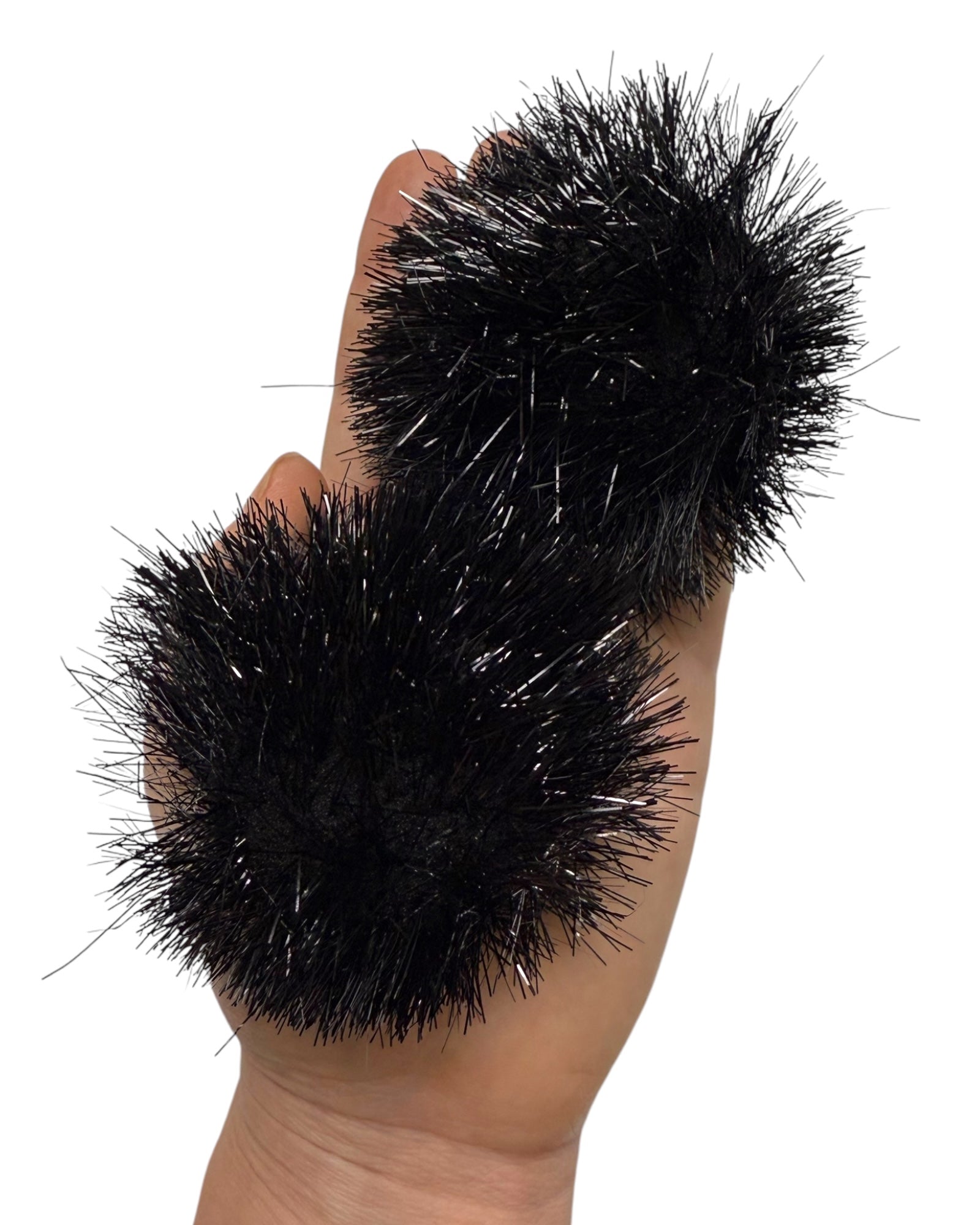 Black Tinsel Space Bunz Pom Poms being held in a hand for size comparison with white background. 