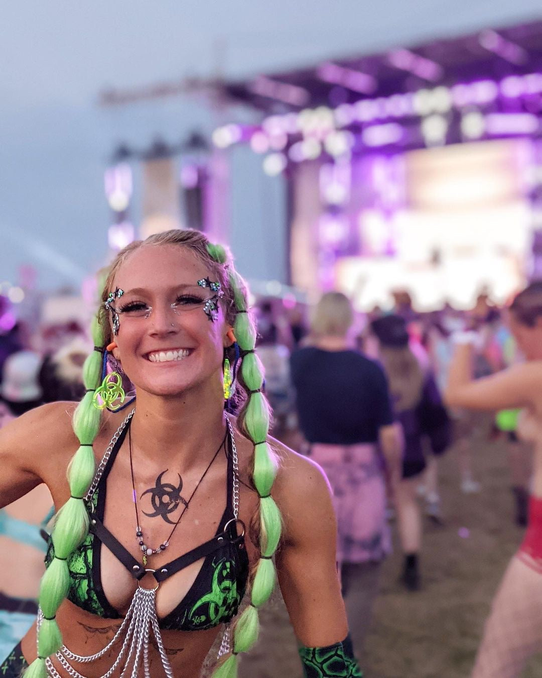 Fluorescent green Biohazard earrings on model at festival