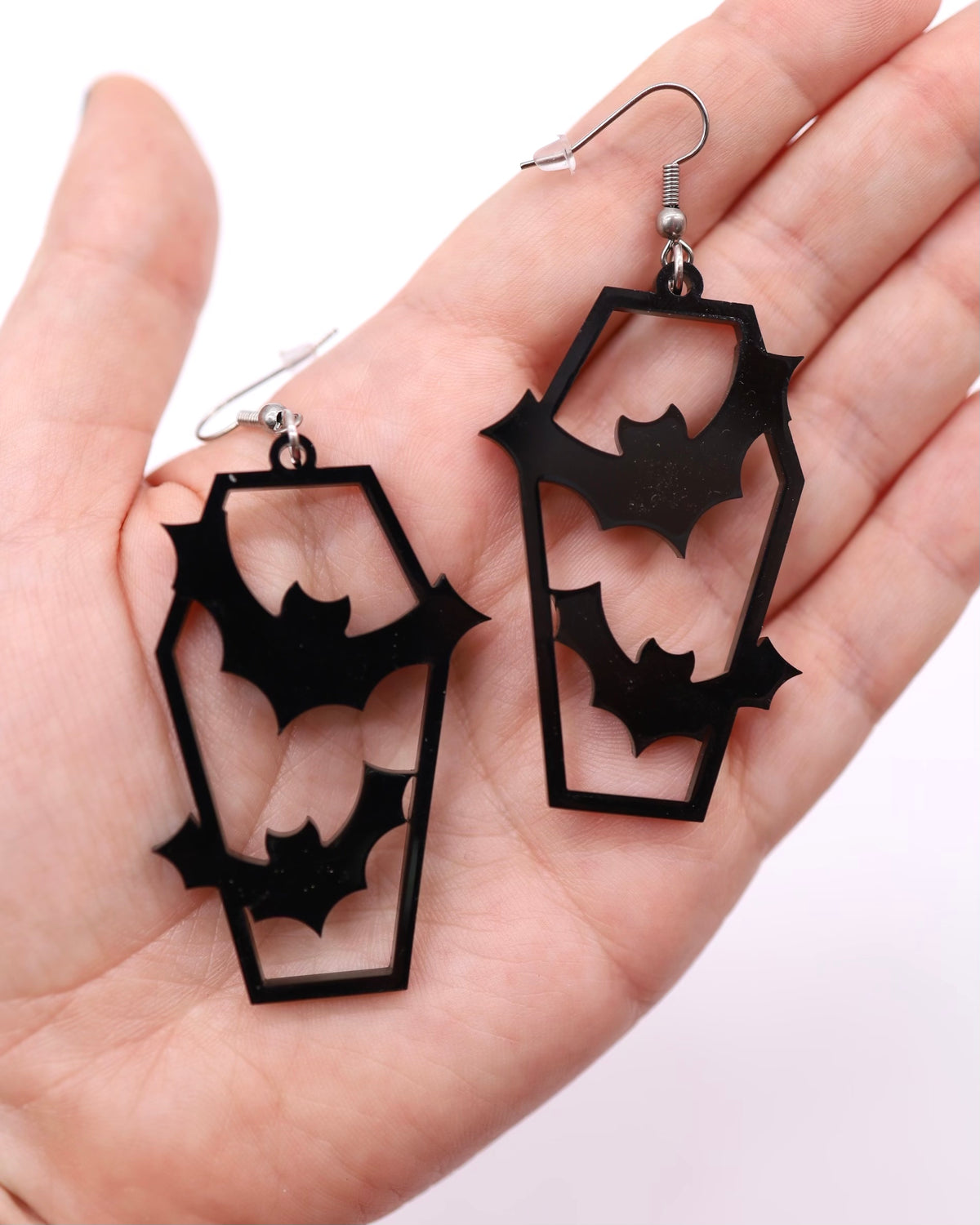 Black acrylic coffin earrings with bats cut out in the middle.