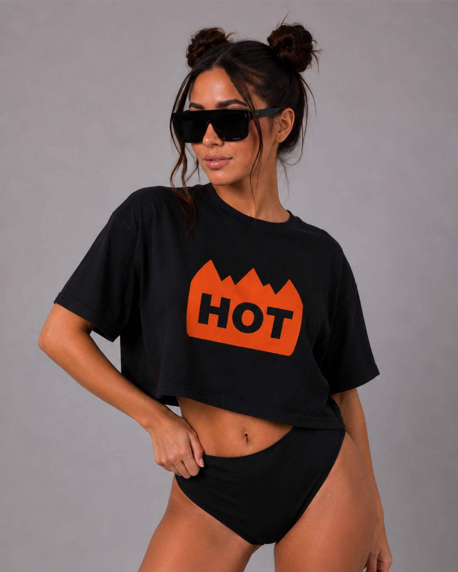 Black oversized cropped T-shirt with an orange "HOT" flame graphic, worn with matching black high-waisted bottoms.