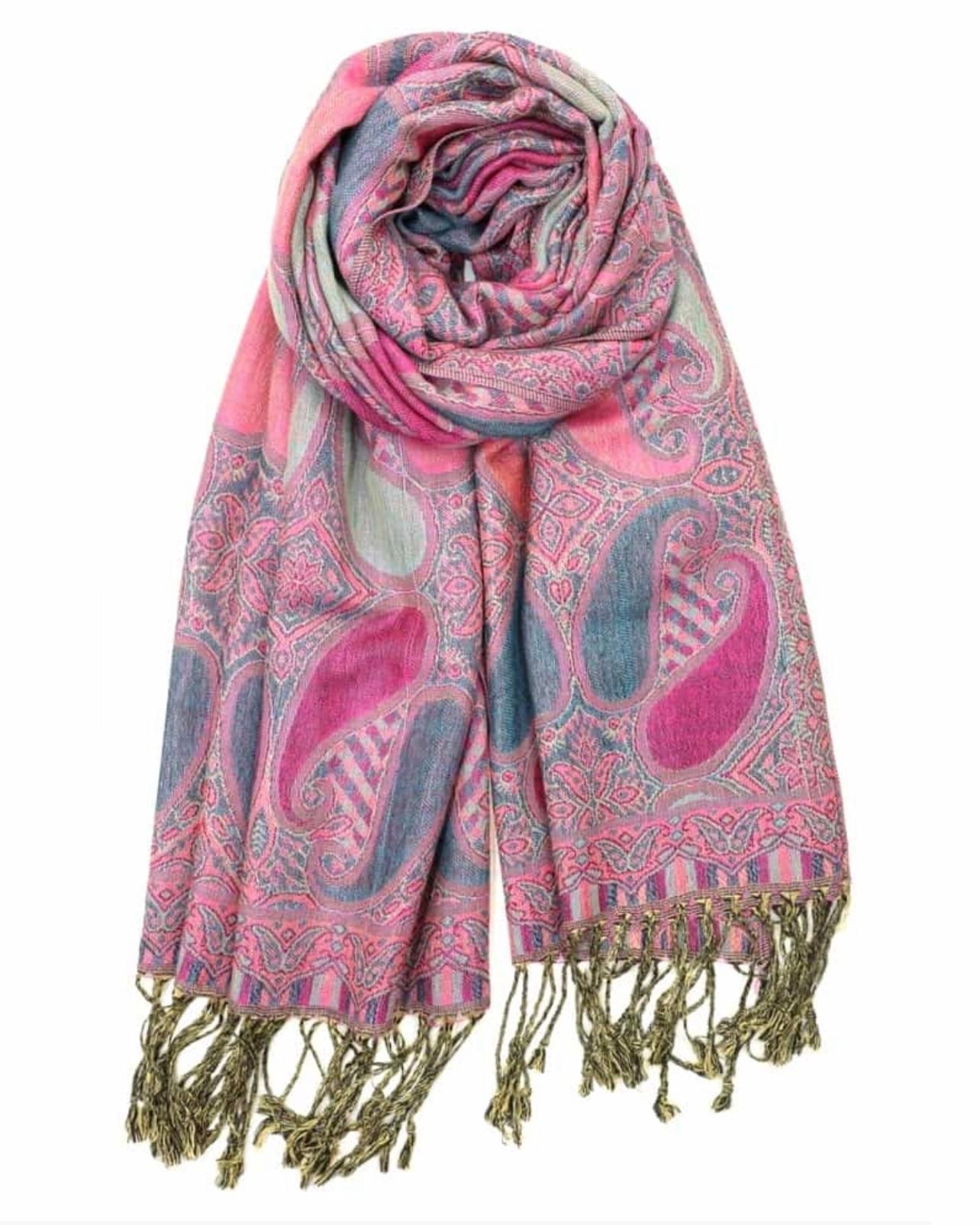 A pink and blue paisley pattern pashmina with fringes displayed on a white background.