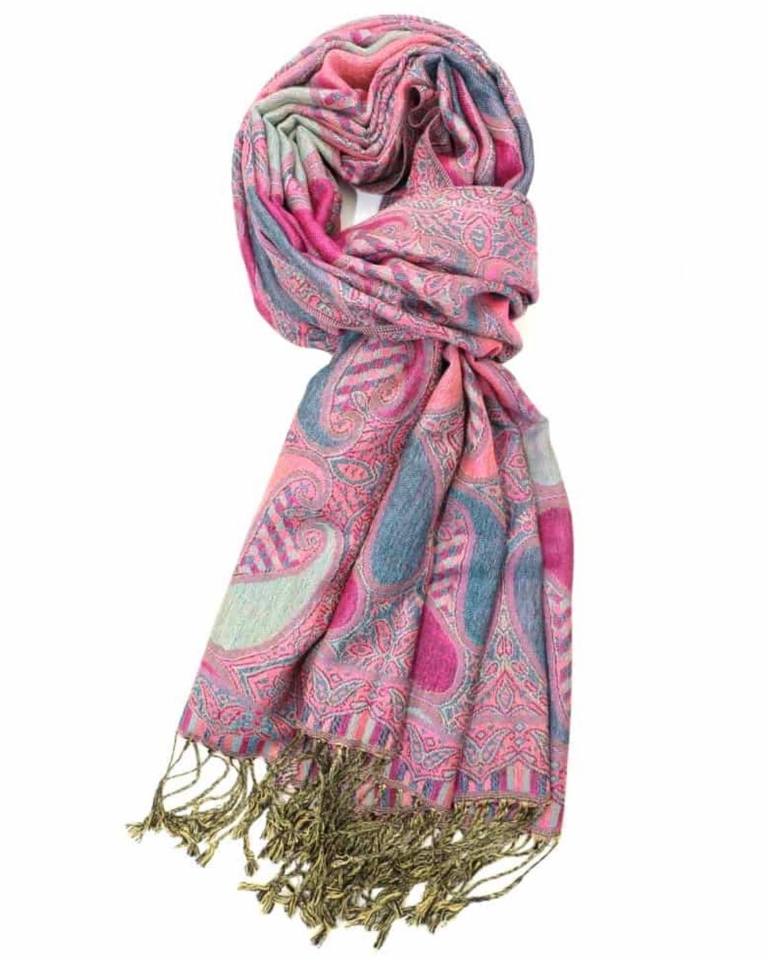 A pink and blue paisley pattern pashmina with fringes displayed on a white background.