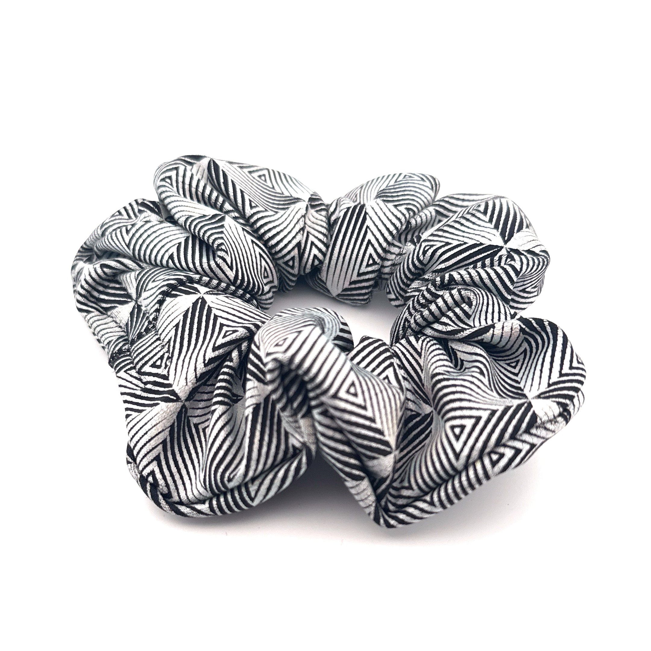 Three black and white patterned scrunchies on a white background