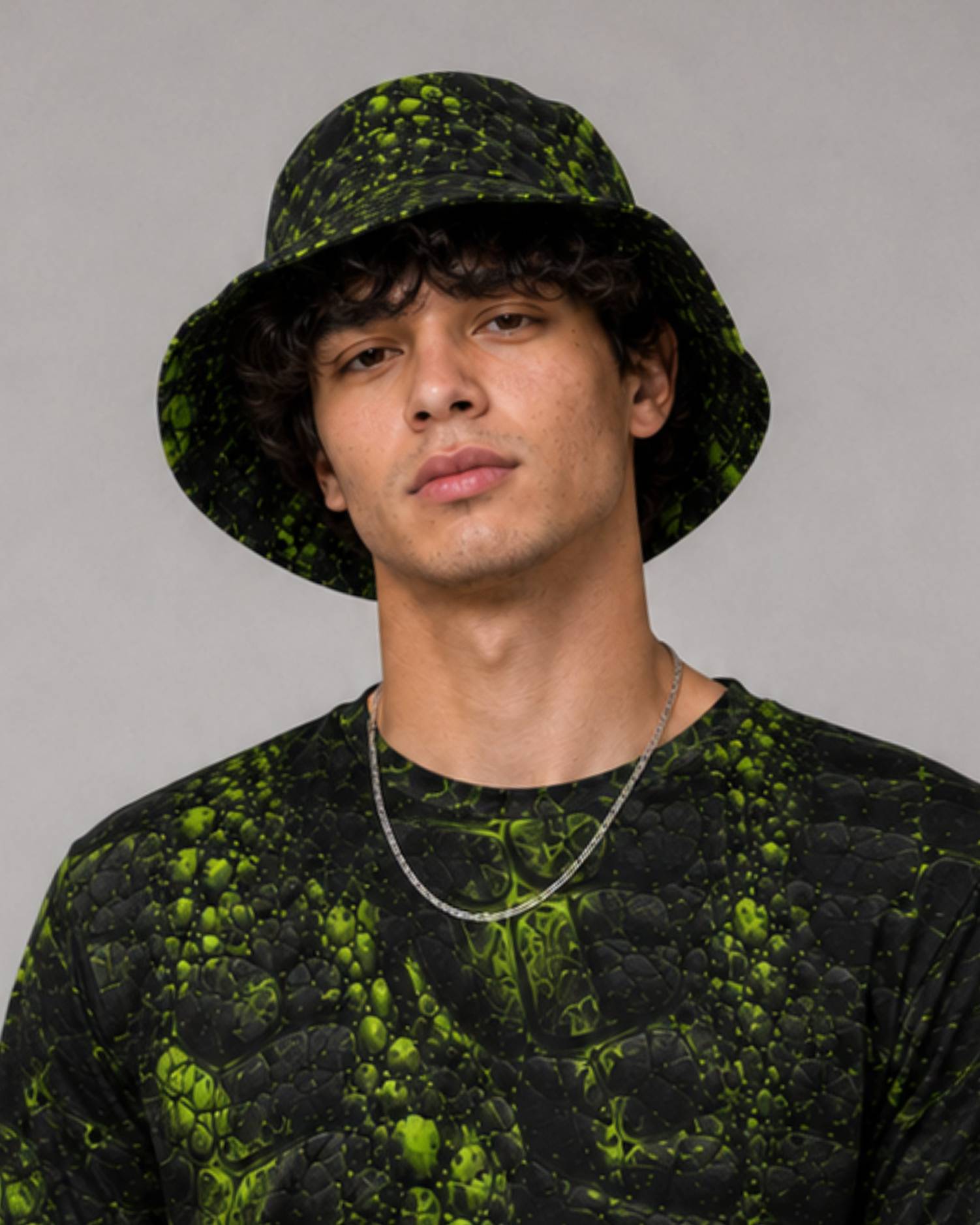 Model wearing a black and neon green cracked-texture Ravage bucket hat and matching t-shirt.