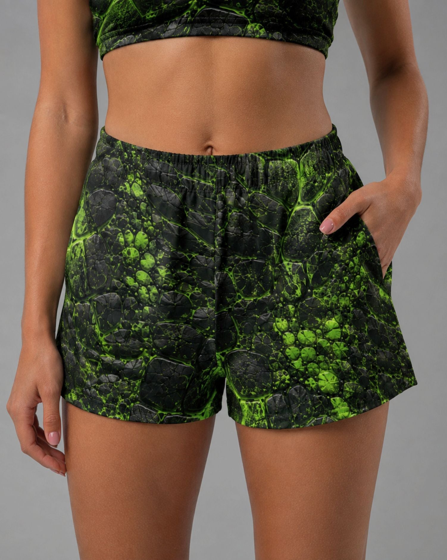 Cropped front view of black and neon green cracked-texture Ravage Kinetic Shorts with side pockets and elastic waistband.
