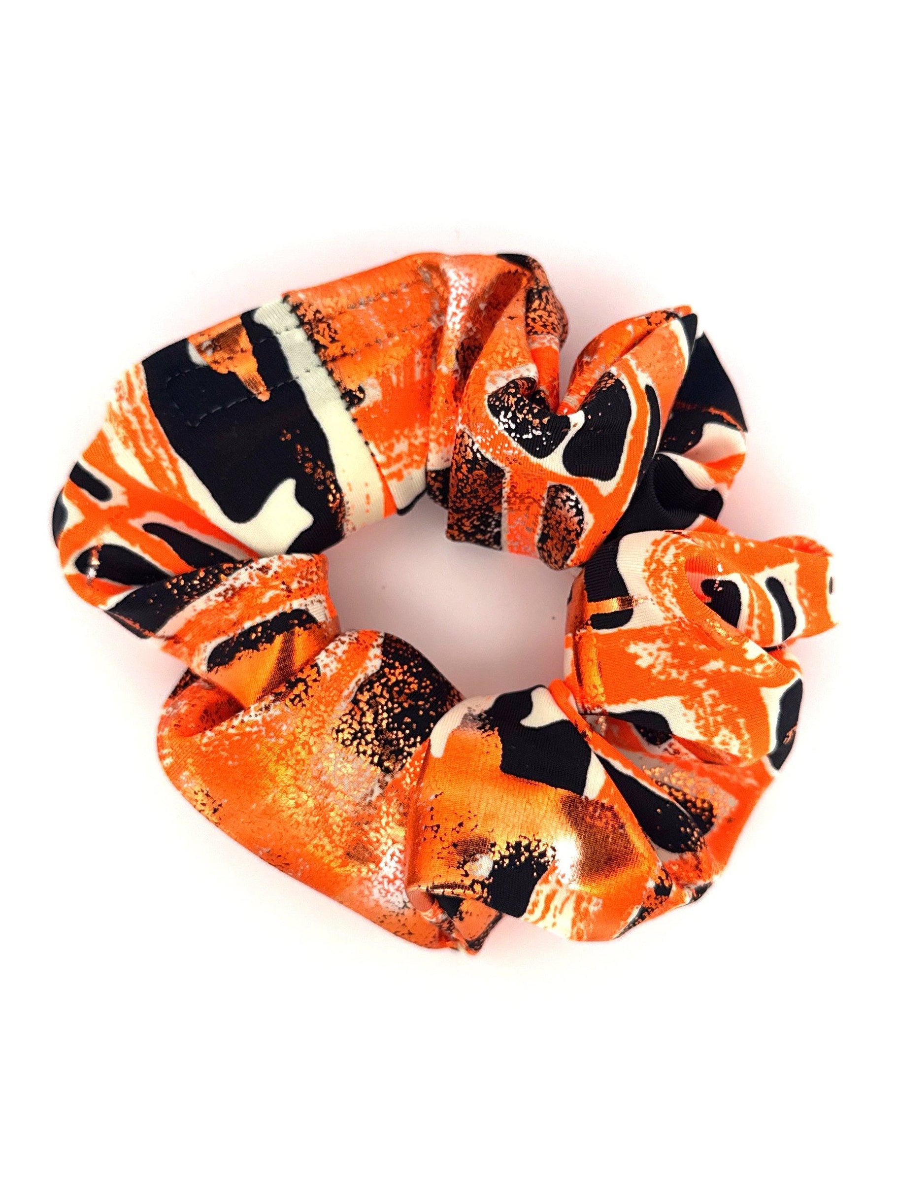 Orange, black, and white patterned scrunchie on a white background