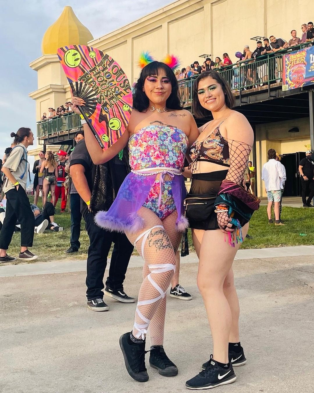 Woman at music festival with House Head Hand Fan and space bunz.