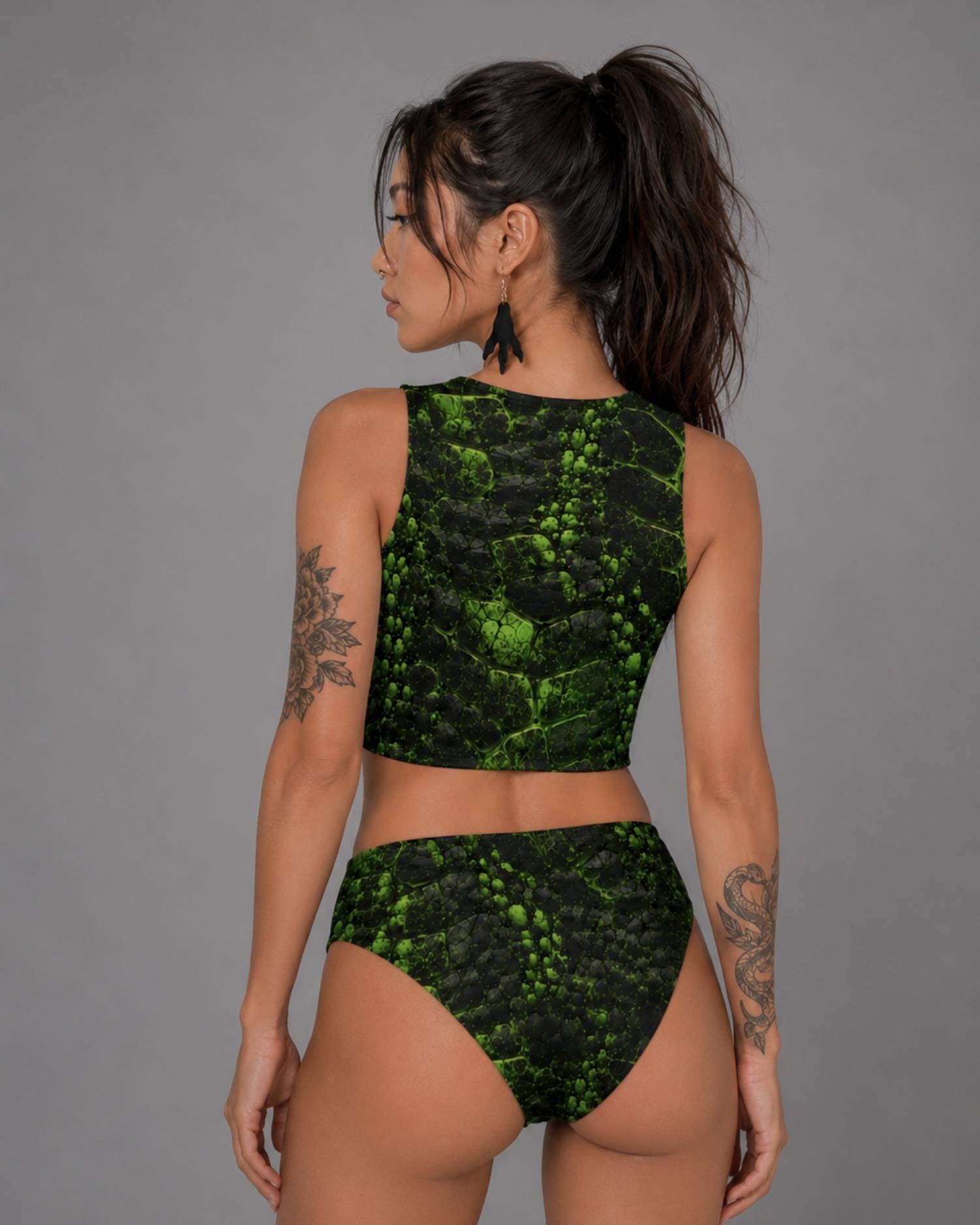 Back view of model in green and black cracked-texture crop top and matching high-waisted bikini bottoms.