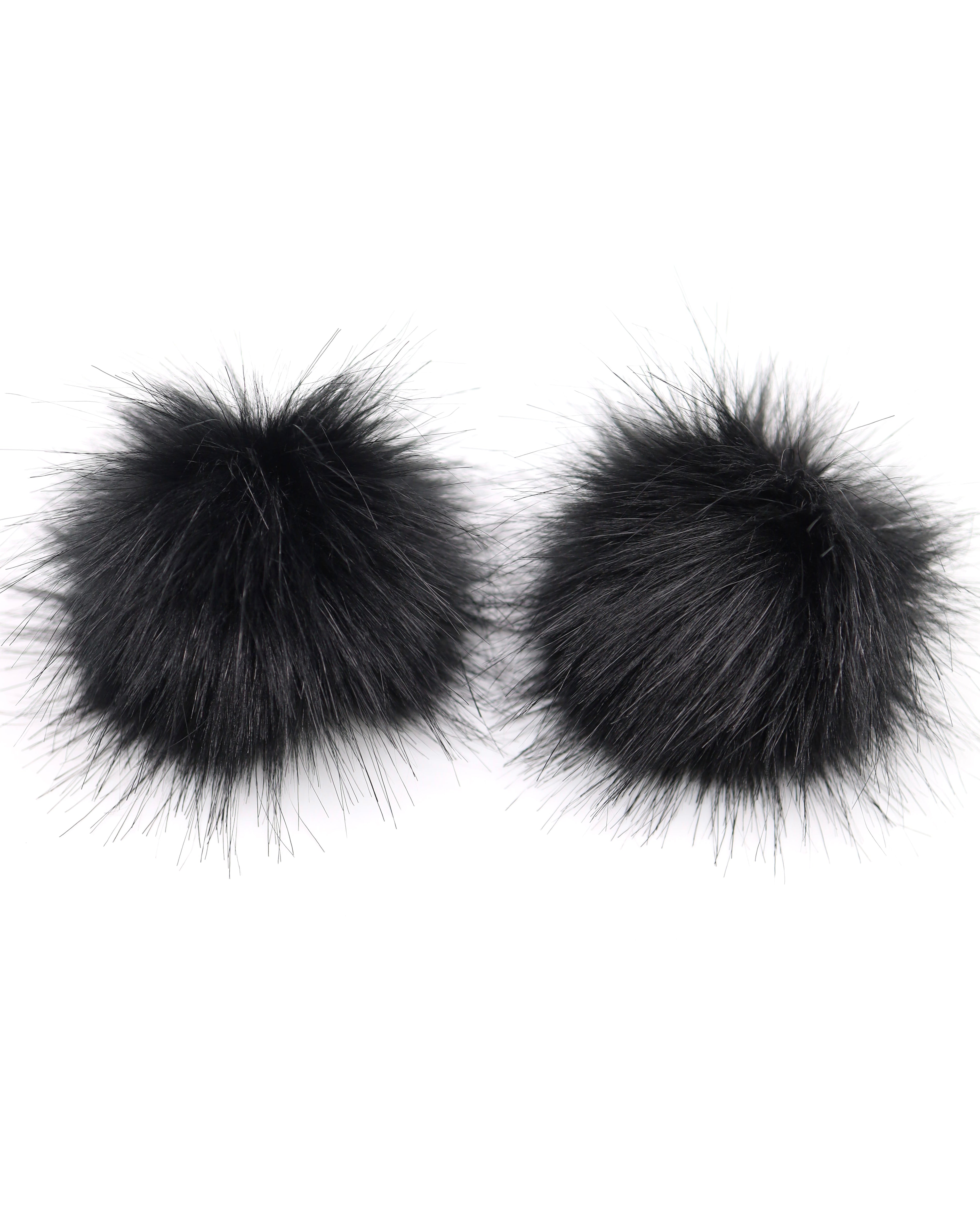 Black Faux Fur Pom Poms with a aligator clip to attach them to your hair on a white background.