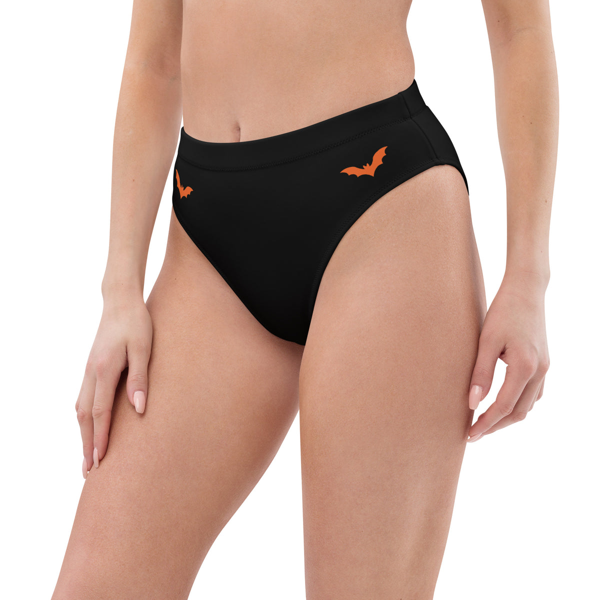 Model wearing high-waisted black rave bottoms with orange bats across the front