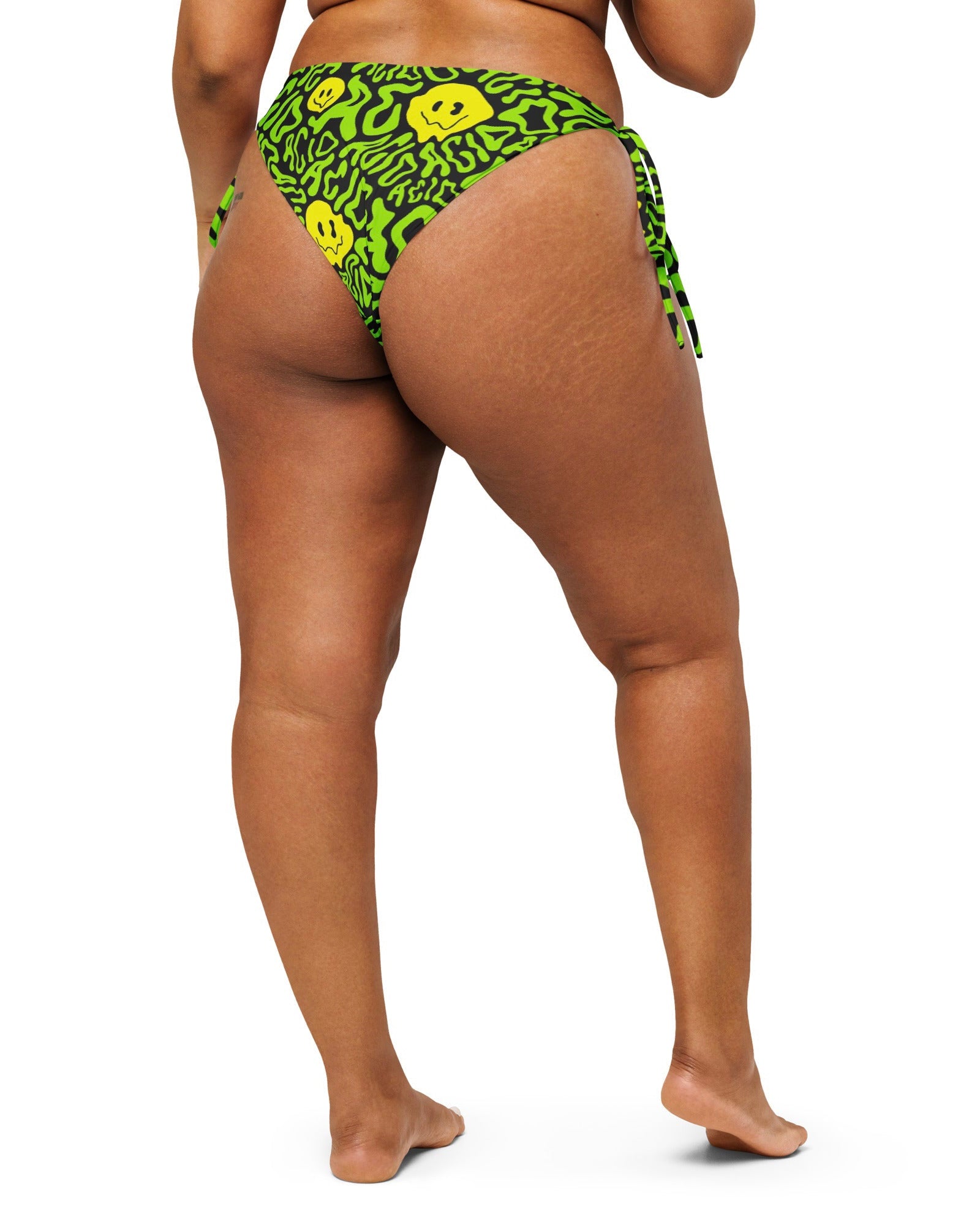 Model showing off the back of the Acid Smilez String Bottoms by One Stop Rave.