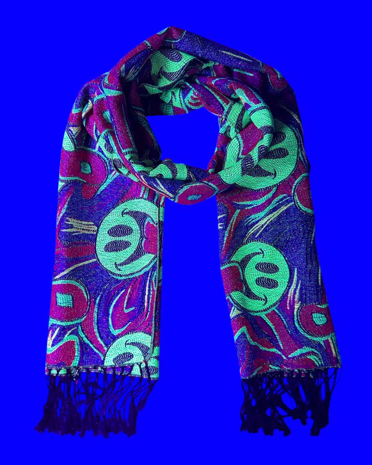 One Stop Rave reversible jacquard festival scarf with neon green smiley faces, purple, and red abstract woven patterns.